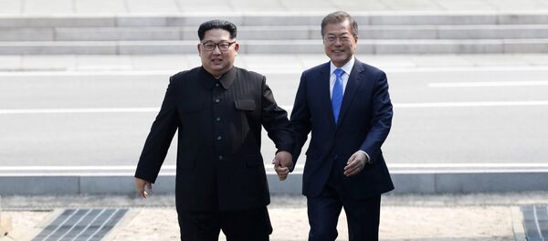 Лидер КНДР Ким Чен Ын и президент Южной Кореи Мун Чжэ Ин за руки пересекают границу в буферной зоне в Пханмунджоме - Sputnik Казахстан