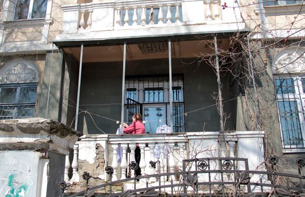 Центр города. Женщина развешивает белье на балконе старинной усадьбы. - Sputnik Казахстан