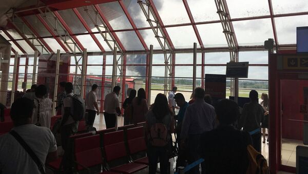 Люди в аэропорту смотрят, как дым поднимается с места, где упал самолет вскоре после взлета из Гаваны - Sputnik Казахстан