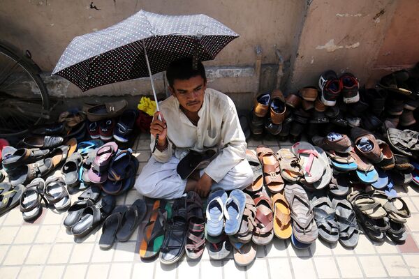 Мужчина охраняет обувь возле мечети в Индии - Sputnik Казахстан
