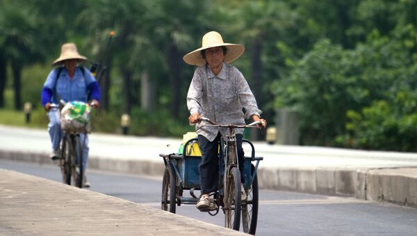 Женщины едут на велосипедах по одной из улиц Шанхая, архивное фото - Sputnik Казахстан