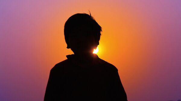 Мальчик стоит на фоне заката, иллюстративное фото - Sputnik Казахстан