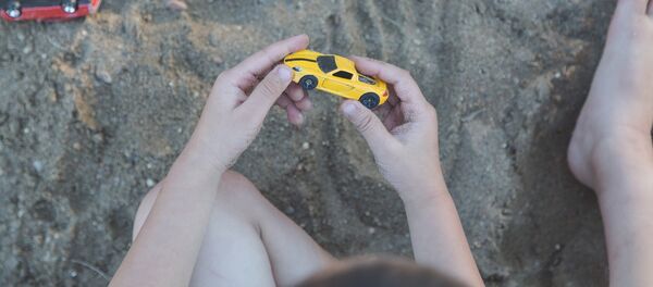Ребенок держит в руках машинку Ребенок держит в руках машинку - Sputnik Казахстан