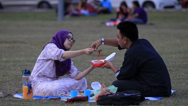 Мужчина и женщина едят в парке, архивное фото - Sputnik Казахстан