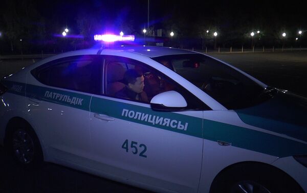 Полицейский беседует с Куанышем Акымом в патрульной автомашине - Sputnik Казахстан