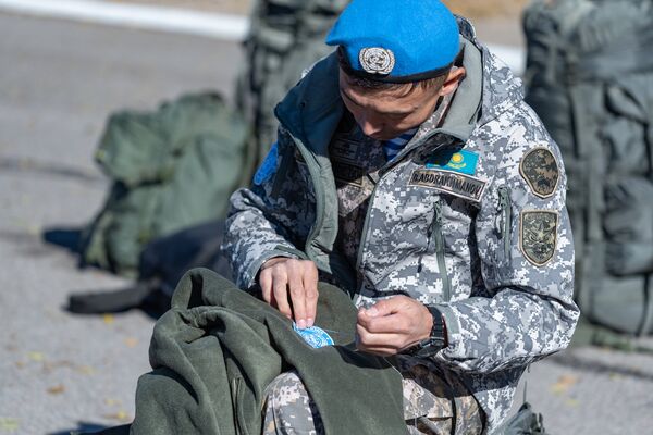 Военнослужащий пришивает шеврон миротворца - Sputnik Казахстан