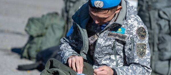Военнослужащий пришивает шеврон миротворца - Sputnik Казахстан