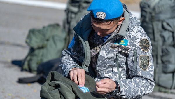 Военнослужащий пришивает шеврон миротворца - Sputnik Казахстан
