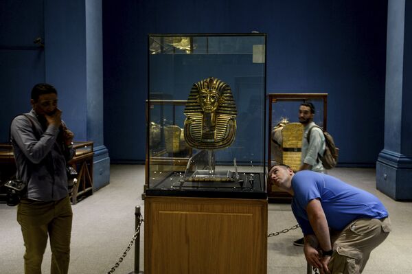 Посетители смотрят на Золотую маску короля Тутанхамона в Египетском музее на Каирской площади Тахрир 5 августа 2018 года - Sputnik Казахстан