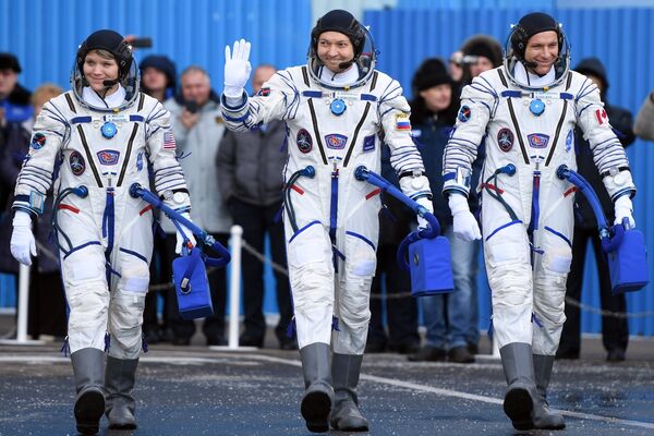 Члены основного экипажа МКС-58/59 (справа налево): астронавт Канадского космического агентства Давид Сен-Жак, космонавт Роскосмоса Олег Кононенко и астронавт НАСА Энн МакКлейн перед стартом ракеты-носителя - Sputnik Казахстан