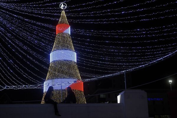 Две девушки у рождественской ели на площади Сальвадора-дель-Мундо в Сан-Сальвадоре, Сальвадор - Sputnik Казахстан