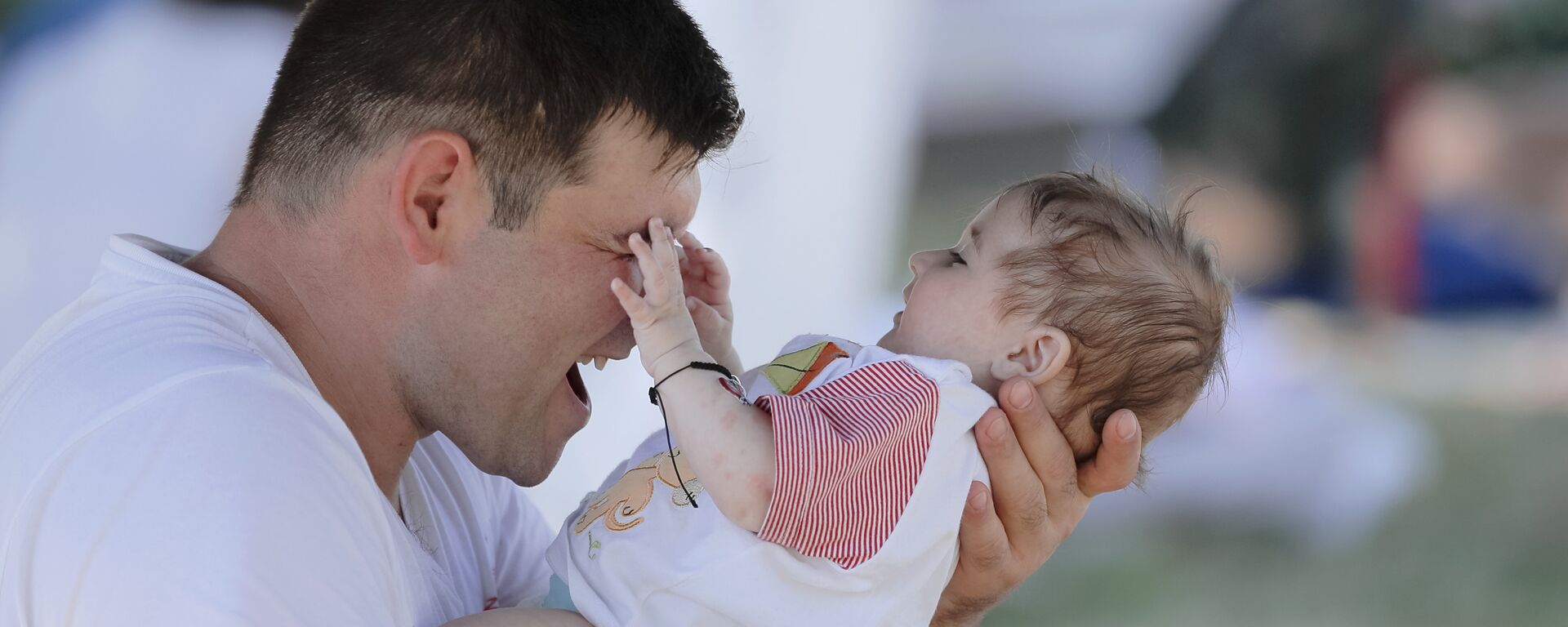 Мужчина держит на руках ребенка - Sputnik Қазақстан, 1920, 23.07.2024