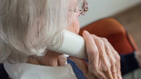 Пожилая женщина говорит по телефону, иллюстративное фото - Sputnik Казахстан