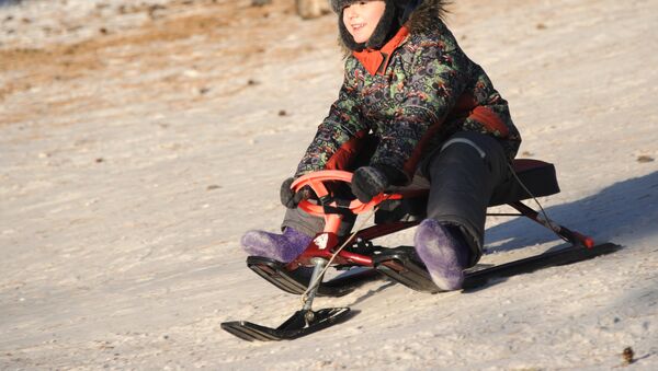 Ребенок катается с горки на снегокате - Sputnik Казахстан