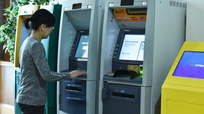 Девушка у банкомата, архивное фото