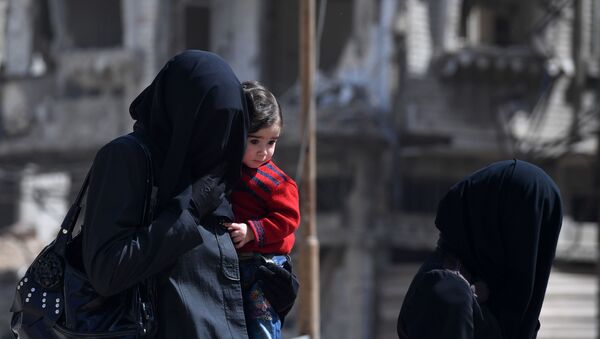 Женщина в хиджабе с ребенком на руках, архивное фото - Sputnik Казахстан