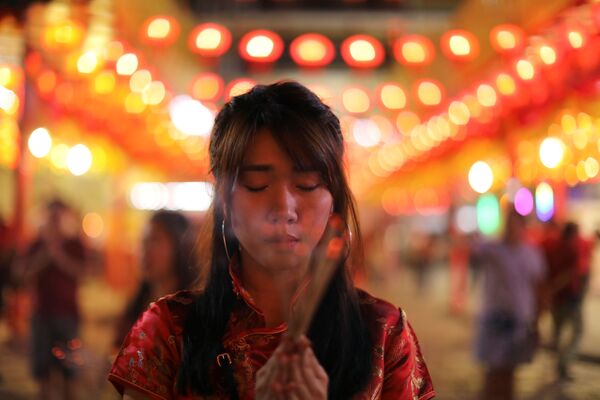 Девушка во время молитвы на праздновании китайского Нового года в Таиланде  - Sputnik Казахстан