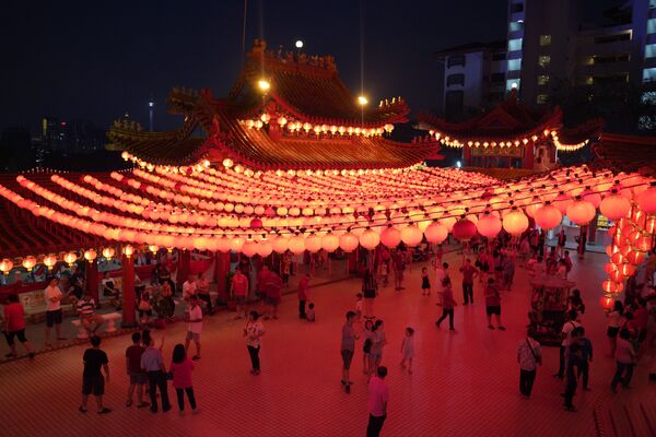 Посетители под красными светильниками в храме в Малайзии  - Sputnik Казахстан