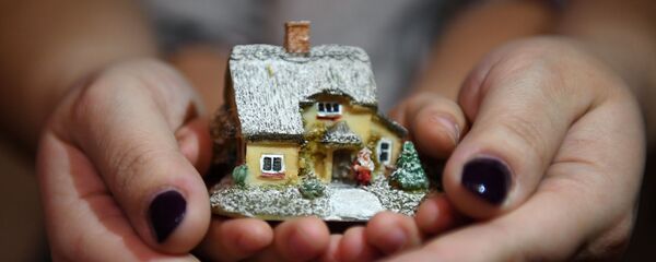 Женщина с ребенком держат макет дома - Sputnik Казахстан