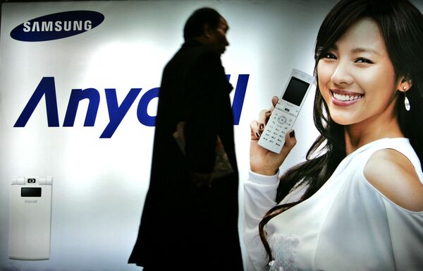 Пешеход идет мимо рекламного щита Samsung Mobile в Сеуле, Южная Корея. 2007 год - Sputnik Казахстан