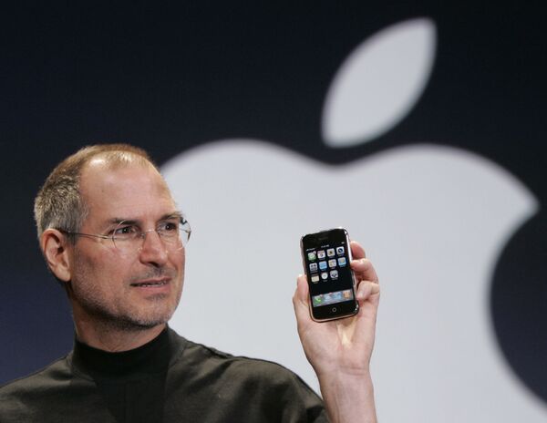 Глава корпорации Apple Стив Джобс держит Iphone на конференции MacWorld в Сан-Франциско, 2007 год - Sputnik Казахстан