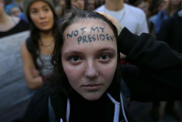 Участница акции протеста против избранного президента Дональда Трампа с надписью на лбу не мой президент - Sputnik Казахстан