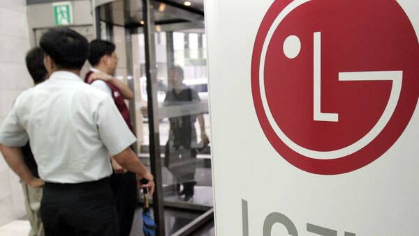 Работники офиса проходят мимо вывески с логотипом LG в штаб-квартире в Сеуле - Sputnik Қазақстан