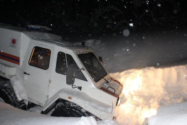Спасатели вытаскивают машину из снега Спасатели вытаскивают машину из снега - Sputnik Казахстан