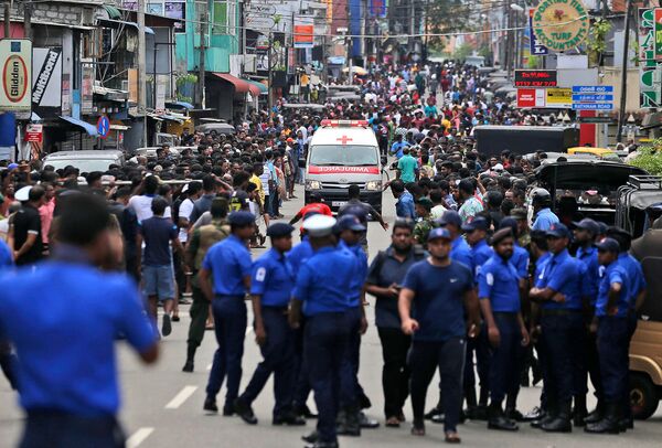 Сотрудники полиции Коломбо освобождают дорогу для кареты скорой помощи, на которой перевозят раненых от взрывов в (21 апреля 2019). Шри-Ланка - Sputnik Казахстан