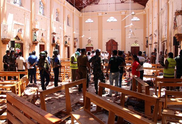Сотрудники Службы безопасности Шри-Ланки проходят через обломки после взрыва в церкви Святого Себастьяна в Негомбо, к северу от столицы Коломбо (21 апреля 2019). Шри-Ланка - Sputnik Казахстан