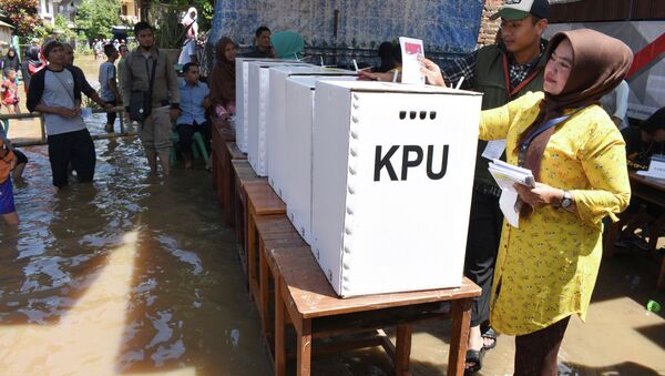Люди голосуют на избирательном участке во время выборов в Индонезии, 17 апреля 2019 года - Sputnik Казахстан