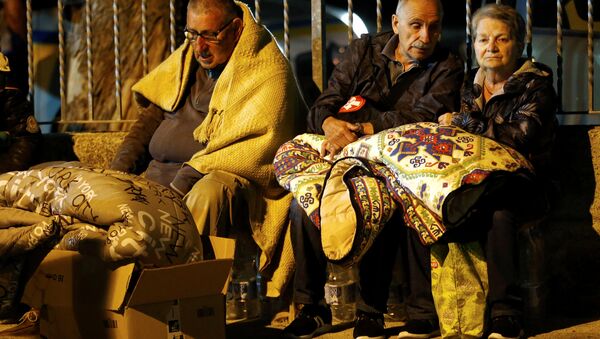 Мужчина укрывается одеялом, готовясь провести ночь под открытым небом после землетрясения в Аматриче (Италия) - Sputnik Казахстан